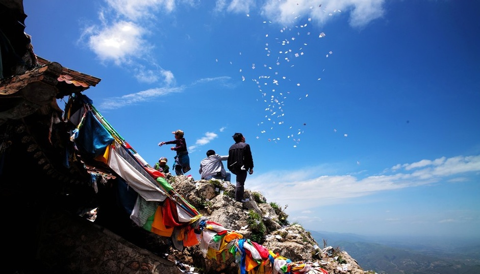 莲花山主峰地带藏民在撒五色风马纸