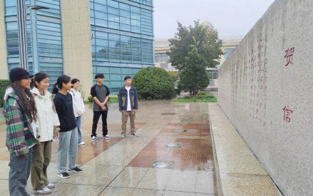 贺信石前，学生们认真阅读习近平总书记贺信 