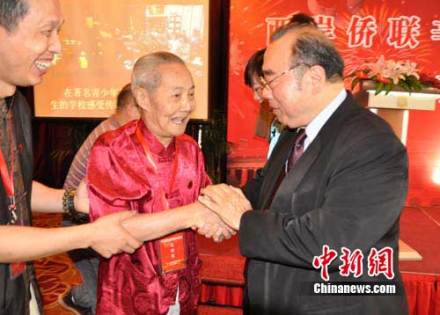 台湾侨联总会理事长简汉生(右)与熊秉坤之子熊辉（中）交谈 