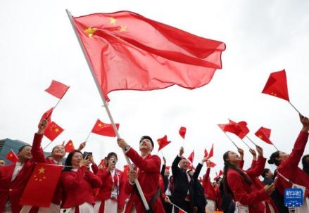 中国体育代表团旗手、乒乓球选手马龙在开幕式前挥舞国旗 
