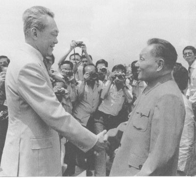 邓小平应邀访问新加坡，在机场与新加坡总理李光耀亲切握手