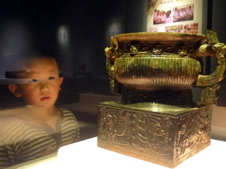 一名孩子在观看展出的文物 