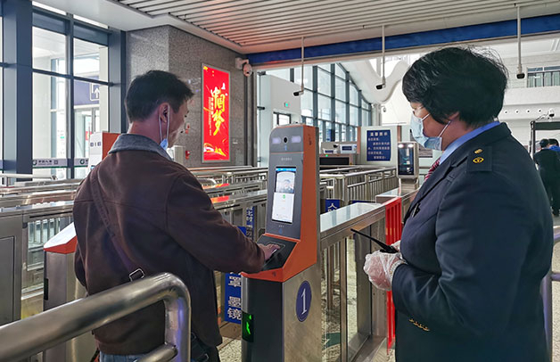 龙岩火车站工作人员指导旅客刷脸进站 