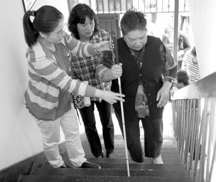 老师指导盲人使用盲杖进行上下楼行走训练