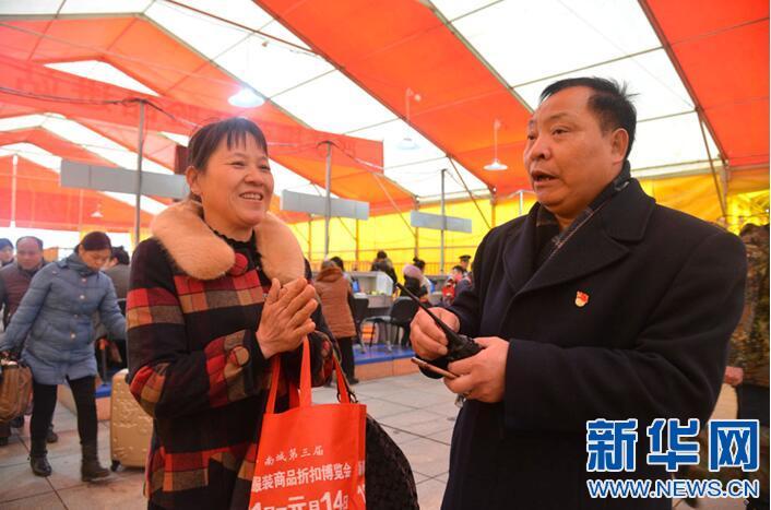 九江火车站的工作人员帮助一名旅客进站乘车 