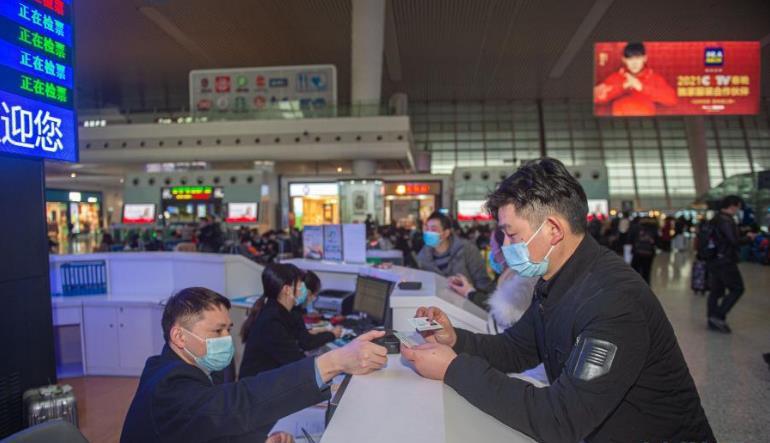 在杭州东站，旅客（右）请工作人员帮忙查询车票信息