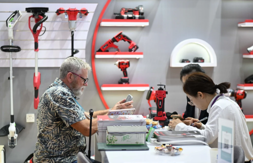 10月15日，境外采购商（左）在一处电动工具展台洽谈