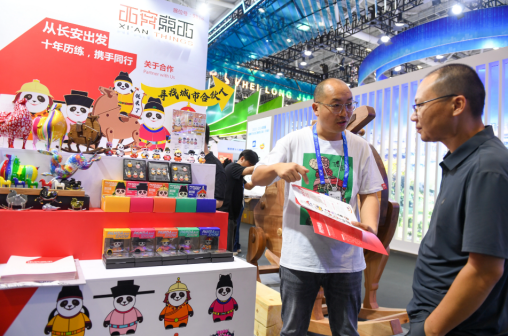 5月23日，参展商在第二十届文博会上向参观者介绍文创产品
