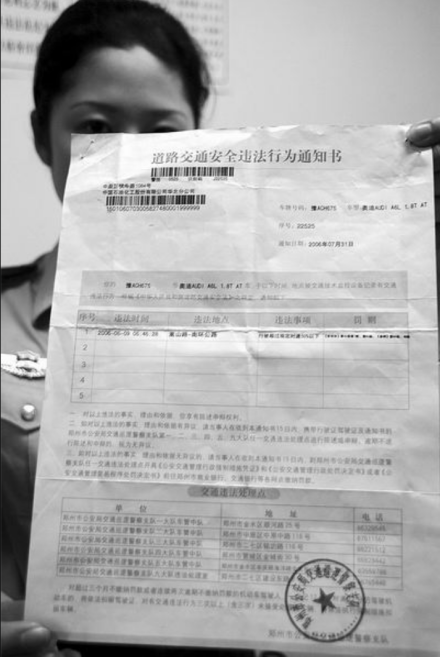 民警展示“道路交通安全违法行为通知书”（2006.8.6摄） 